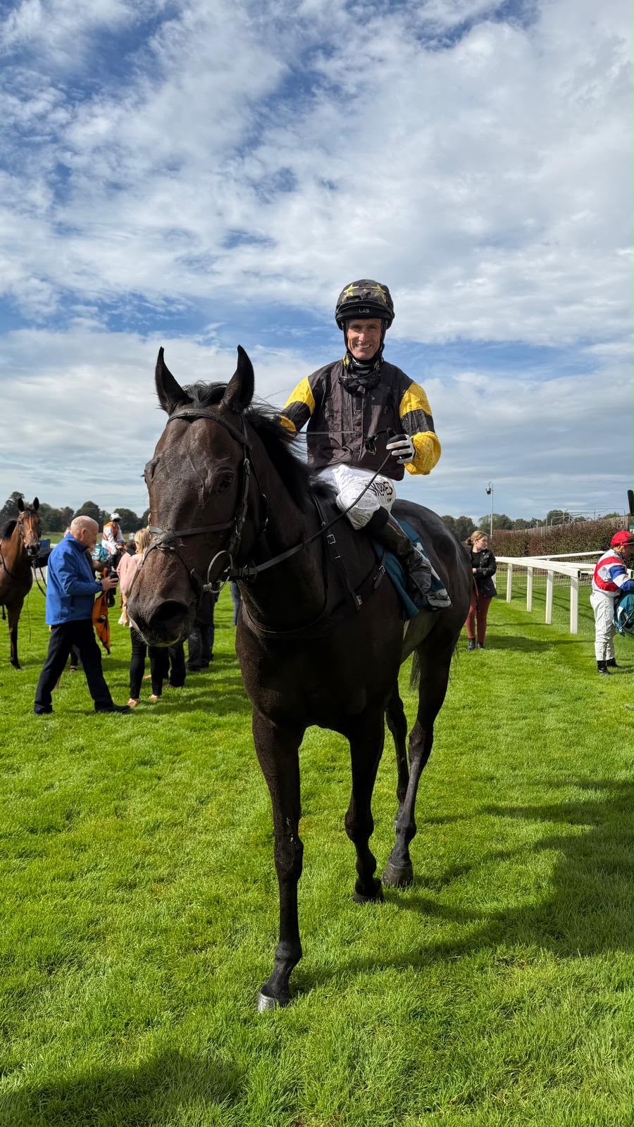 Johnnie Delta Racing jockey on a black racehorse after racing